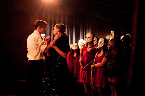 a man and a woman look at each other surrounded by people wearing white masks