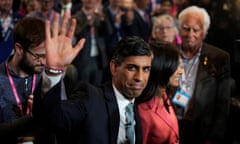 Rishi Sunak waves as he stands next to his wife with people around