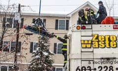 Firefighters rescue a woman from a garbage truck in Manchester, New Hampshire, on 29 January 2024.