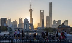 Cyclists take selfies as they take a rest against the sunrise in Pudong, China's financial and commercial hub, in Shanghai, China