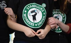 people link arms wearing shirts that say "Starbucks workers united"