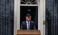 Rishi Sunak stands at a podium outside No 10 in the rain. His suit is drenched and he is looking down at the podium