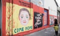 A large, colourful mural with the face of a young boy on a yellow and red background, with the words 'Tal Goldstein, 9 years old' and 'Come home'. Next to it is another mural bearing the words 'Let there be light'.