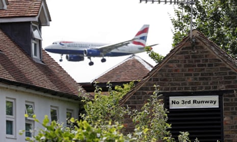 A sign in the village of Longford reads 'No 3rd Runway' as a British airways aircraft prepares to land at Heathrow airport in west London.