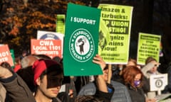 people hold signs in support of unionized Starbucks workers