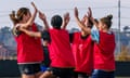 Women football players celebrate in training.