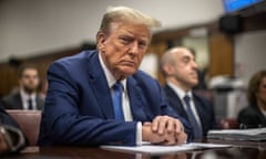 a man in a blue suit and blue tie sits in court