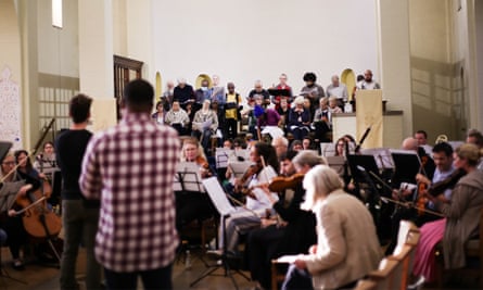 A large group of performers in a rehearsal space