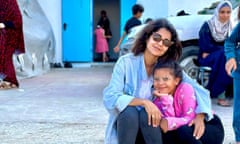 Jamileh Tawfiq, Palestinian journalist in Gaza, posing with a little girl, both wearing glasses.