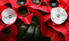 A red poppy wreath decorated with white poppies of peace.