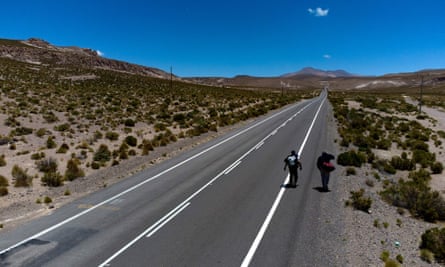 Venezuelan migrants walk along the highway that links Iquique with Colchane after crossing from Bolivia, in Quebe, Chile.