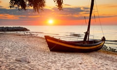 boat on sandy beach at sunset