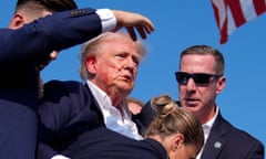 Donald Trump is surrounded by Secret Service agents as he leaves the stage at a campaign rally, in Butler, Pennsylvania, on 13 July. 