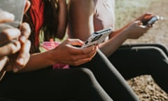 Three woman holding their mobile phones outside and looking at the screens