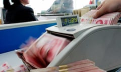 A Chinese bank staff counts renminbi banknotes at a branch of the China Construction Bank in Hai'an