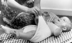 Mother putting a cloth / cotton nappy on a little baby