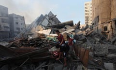Palestinian children search among the rubble of 15-storey Basha Tower in Gaza.