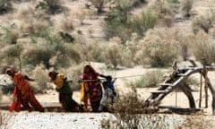 Women struggle to get water from a well in famine-hit Deeplo, Sindh province, Pakistan, March 2014.