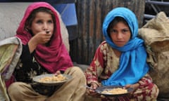 Afghan children eat a meal of rice in Jalalabad: The war-torn country still faces poverty, unemployment and lack of infrastructure despite western aid money which has flooded Afghanistan in the 11 years since a US-led invasion.