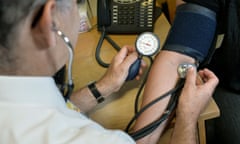 A GP checking a patient's blood pressure