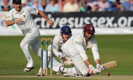 Somerset's Marcus Trescothick sweeps as Sussex wicketkeeper Ben Brown looks on at Hove