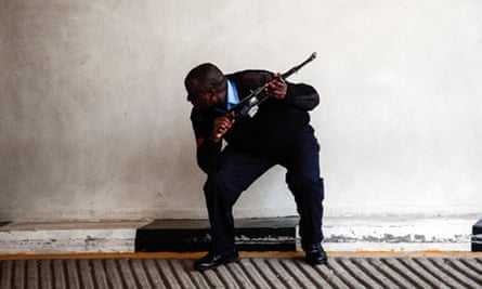 An armed offical stands guard at the Westgate shopping mall after a shootout in Nairobi, Kenya