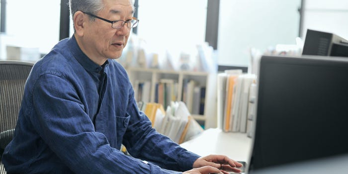 senior professional typing on laptop at office