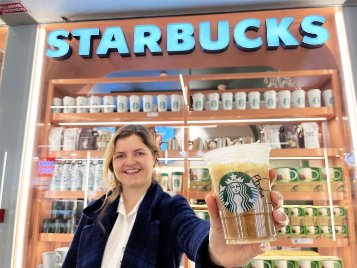 phoebe in front of starbucks in florence, italy, holding iced drink