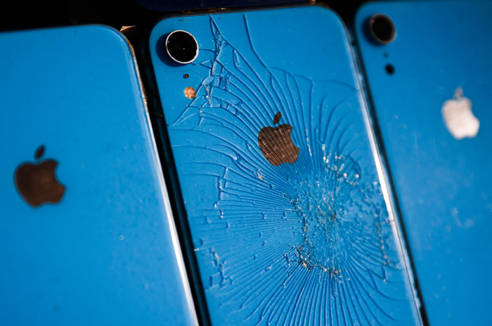 A smashed iPhone is pictured next to two intact iPhones