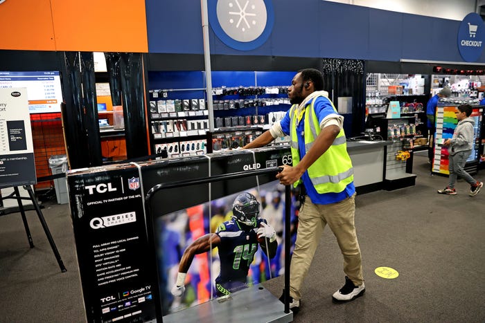 A home Depot employee moves a TV on Black Friday.