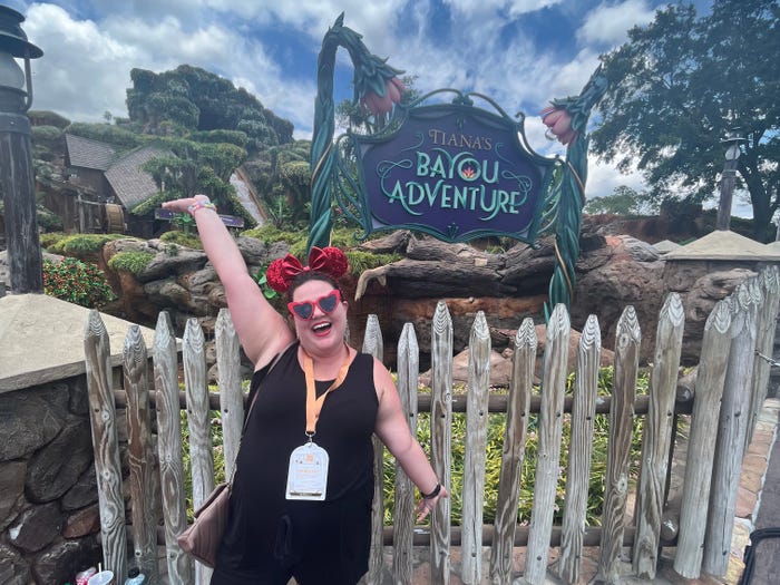 megan posing in front of tiana's bayou adventure in magic kingdom