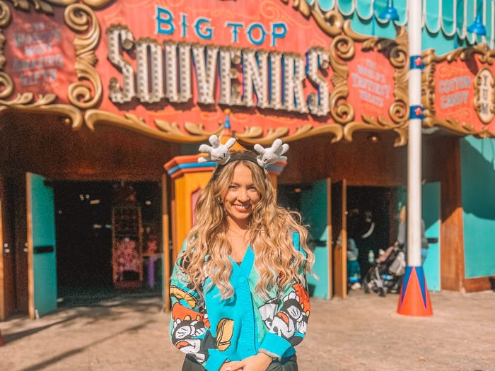 kayleigh posing in front of big top souvenirs at magic kingdom