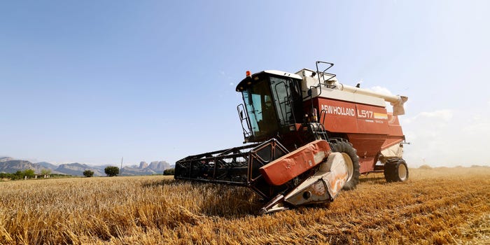 Spanish farmers using a machine to mow a wheat field.