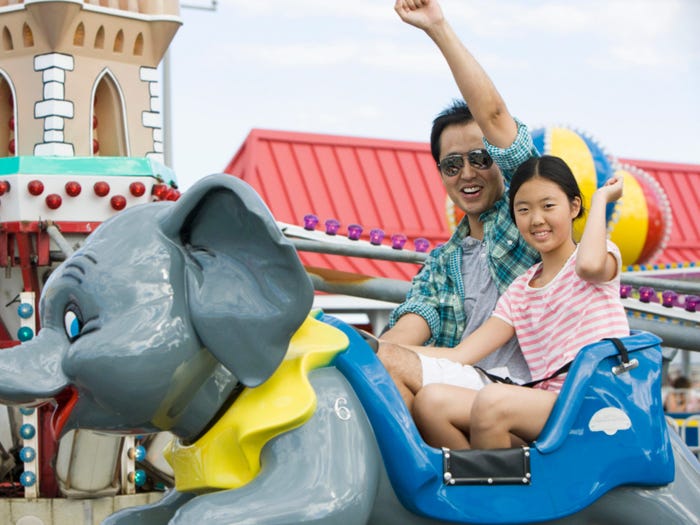 a parent and child on a dumbo ride