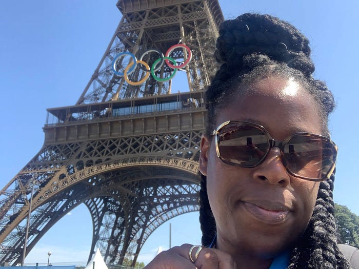 Manseen is taking a selfie in front of the Eiffel Tower.