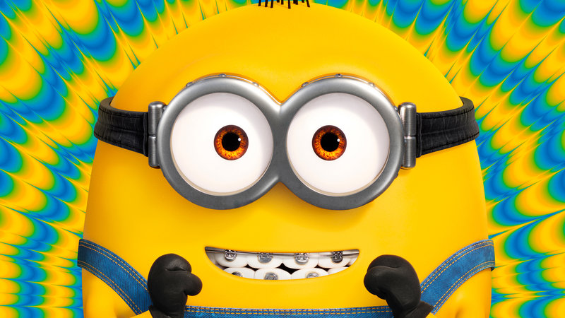Minions The Rise of Gru 2022 movie depicting a minion smiling while staring at the camera.