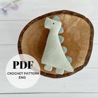 Crochet Dinosaur Patern, Digital Product, PDF Dino Toy Pattern, Dinosaur Rattle Pattern  Crafting a crochet dinosaur rattle for someone special is a heartfelt gift. Select soft, vibrant yarn and an appropriate hook size. The crochet pattern includes instructions to make your own special dinosaur rattle. Using stitches like single crochet, increases, and decreases, the pattern guides you through creating a charming, huggable toy. Personalize it with unique color combinations or added details, ensuring it becomes a treasured keepsake for your loved one.  This is the pattern of DINOSAUR RATTLE, NOT A FINISHED PRODUCT!!!
