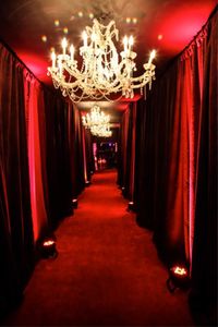 Using pipe-drape and red LED lights and ceiling chandeliers dripping with crystals can create this glorious scene.