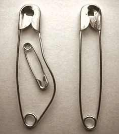 two pairs of tongs sitting on top of a table next to eachother