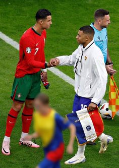 two soccer players shaking hands with each other on the field during a match between spain and portugal