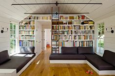 a living room filled with furniture and bookshelves next to each other on top of wooden floors