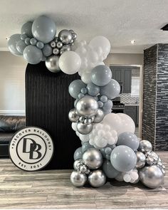 the balloon arch is decorated with silver and white balloons