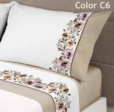 an image of a bed with white sheets and flowers on the pillow cases in color c6