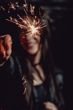 a woman holding a sparkler in her hand