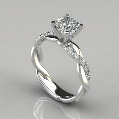 a white gold ring with an oval shaped diamond in the center and twisted band around it