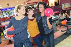 three young women playing bowling in a bowling alley stock photo - 958972