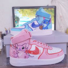 two sneakers with cartoon characters painted on them sitting in front of a computer screen and monitor