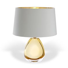 a yellow glass table lamp with a white shade on the base and a light grey fabric shade