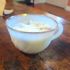 a candle in a bowl on a wooden table