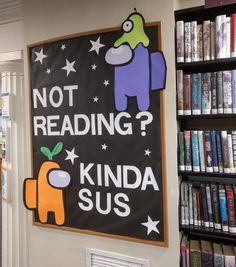 a sign that reads not reading kinda sus in front of bookshelves